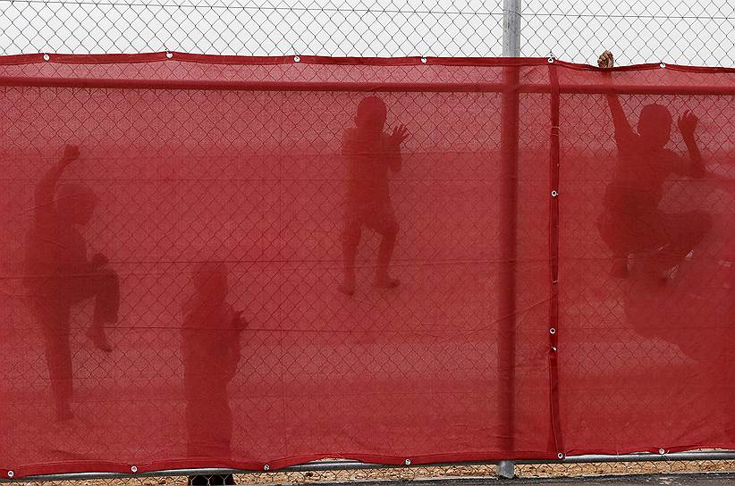 Азрак, Иордания. Дети сирийских беженцев карабкаются на забор, чтобы посмотреть на мастер-класс для футбольных тренеров