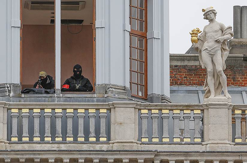 Брюссель, Бельгия. Сотрудники спецслужб в окне здания на площади Гран-Плас, несущие дежурство из-за усиления мер безопасности в связи с террористической угрозой