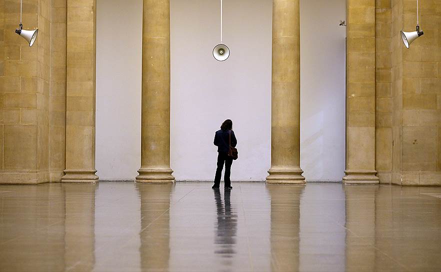 Лондон, Великобритания. Посетитель, слушающий звуки из громкоговорителей на выставке «Музыкальные инструменты, поврежденные войной» в художественном музее Тейт-Британия