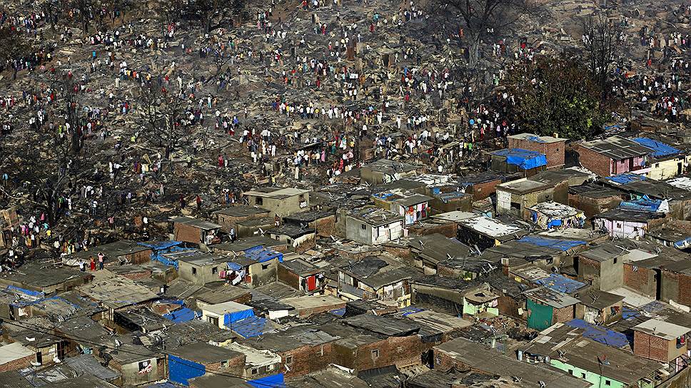 Мумбаи, Индия. Местные жители в поисках уцелевших вещей после сильного пожара, уничтожившего сотни домов в трущобном районе города