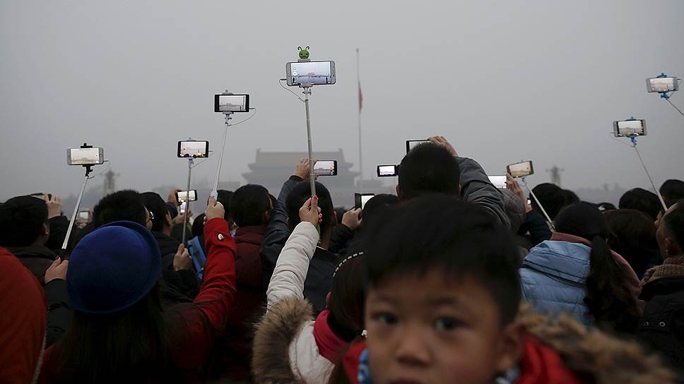 Пекин, Китай. Туристы во время церемонии церемонии поднятия флага на площади Тяньаньмэнь