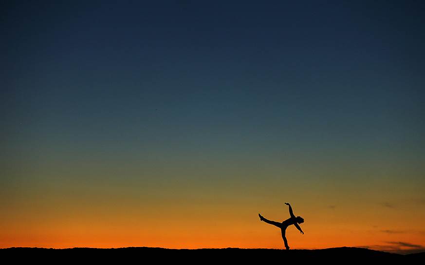 Калифорния, США. Бывший танцор Люк Виллис на пляже после заката