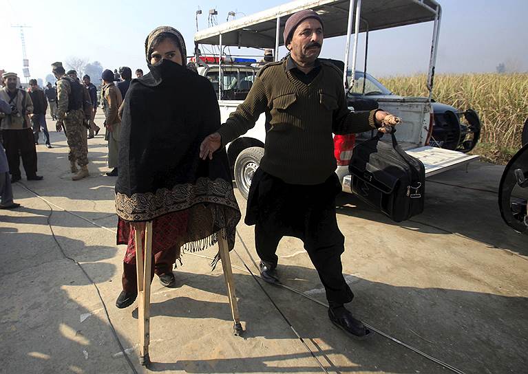 Чарсадда, Пакистан. Выжившая в ходе нападения группы боевиков на университет в городе Чарсадда учительница идет на костылях. В результате атаки погибли 25 человек