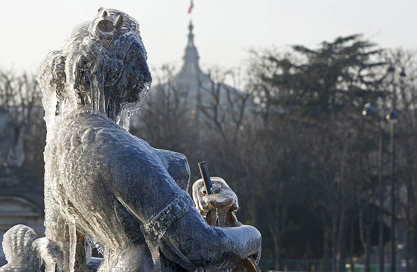 Париж, Франция. Замерзшая статуя у фонтана на площади Согласия 