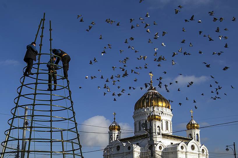 Рабочие демонтируют рождественские  украшения с фасада Храма Христа Спасителя в Москве