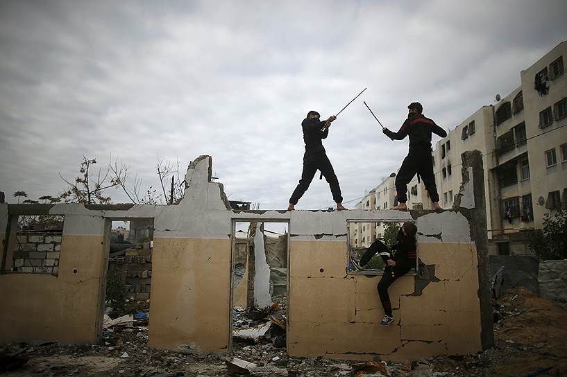 Газа, Палестина. Молодые люди тренируются в боевых искусствах ниндзя на руинах дома, разрушенного во время войны с Израилем в 2014 году