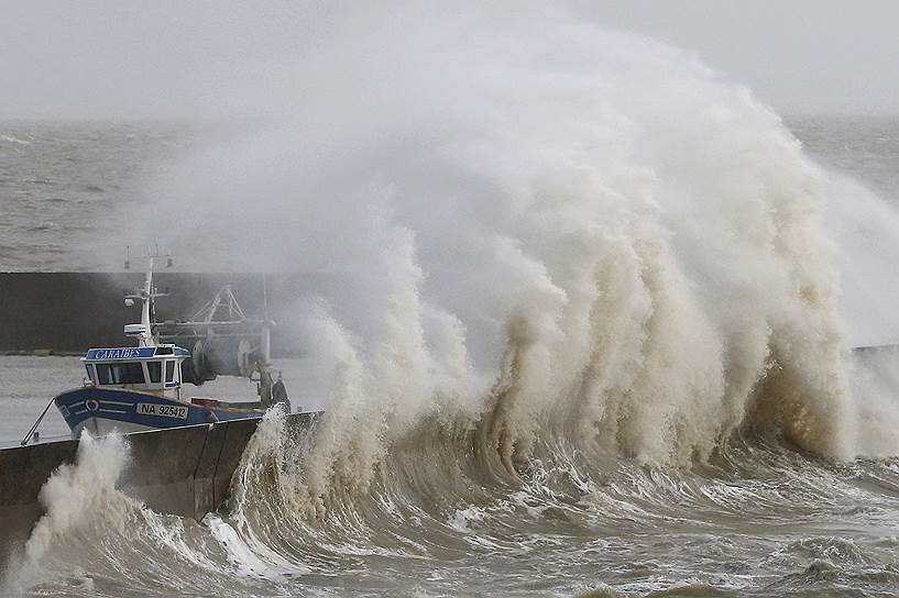 Порник, Франция. Штормовые волны, разбивающиеся о защитные стены рыбацкой гавани