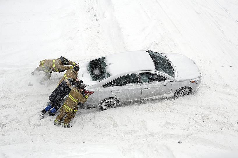 Оттава, Канада. Пожарные толкают автомобиль, застрявший в снегу