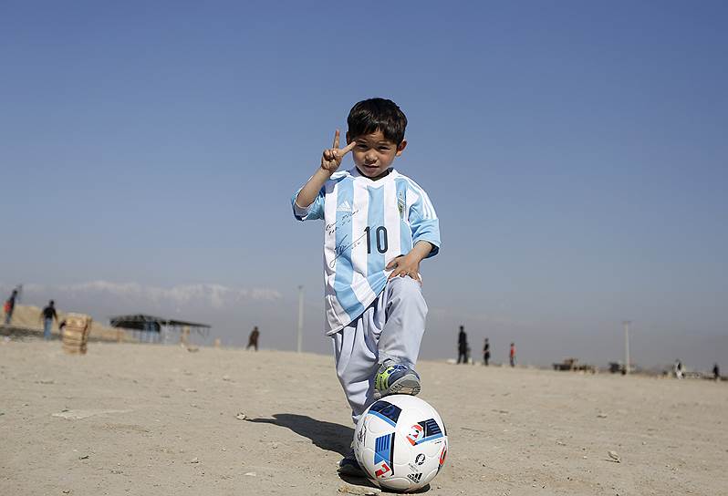 Кабул, Афганистан. Пятилетний Муртаза Ахмади, позирующий в футболке и с мячом, подаренными ему футболистом Лионелем Месси. Мальчик прославился после того, как были опубликованы фотографии, на которых он играет в футбол в полосатой «футболке», сделанной из пластикового пакета
