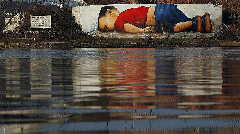 Франкфурт, Германия. Граффити возле здания Европейского центрального банка на берегу Майна, изображающее 3-летнего мигранта Айлана Курди, утонувшего в Средиземном море