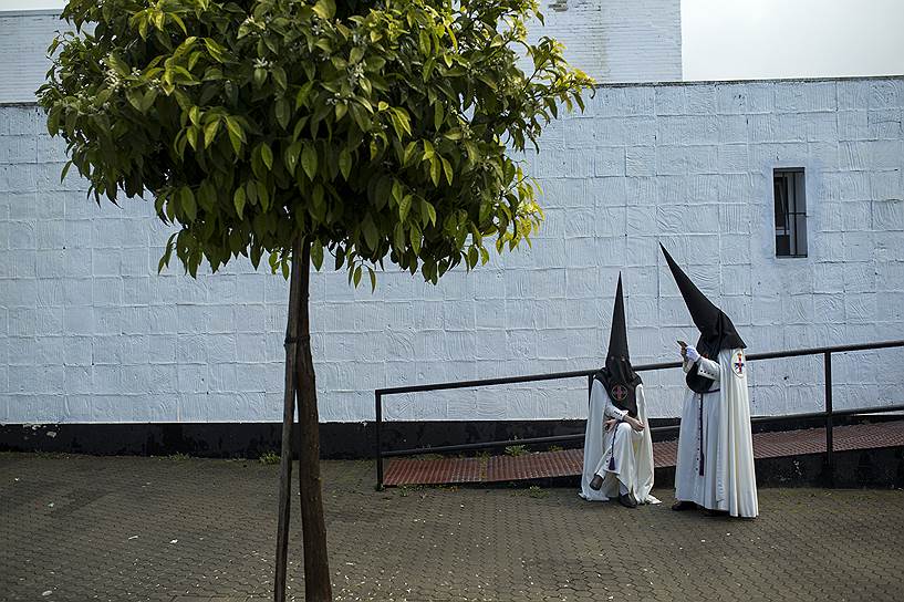 Севилья, Испания. Участники религиозной процессии ждут у церкви в первый день Страстной недели