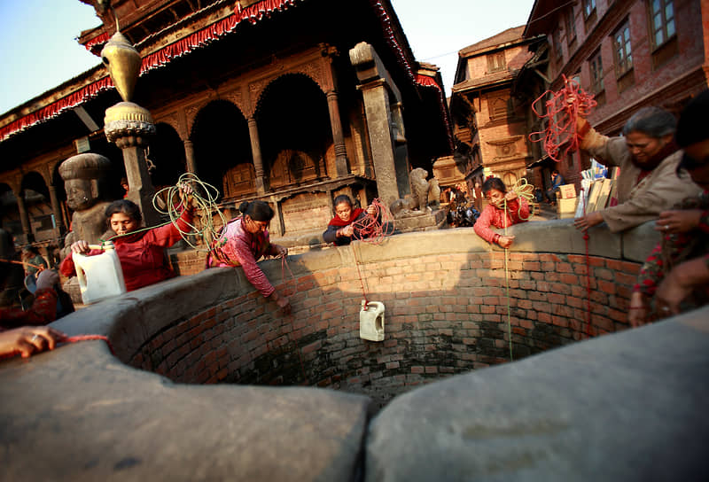 На фото: непальские женщины пытаются наполнить водой емкости из почти высохшего колодца в Бхактапуре