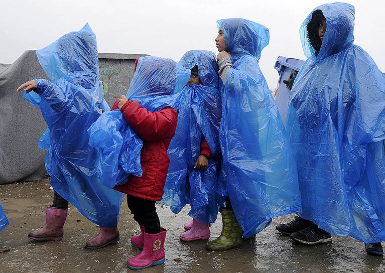 Греко-македонская граница, деревня Идомени, Греция. Дети в непромокаемых плащах в лагере беженцев