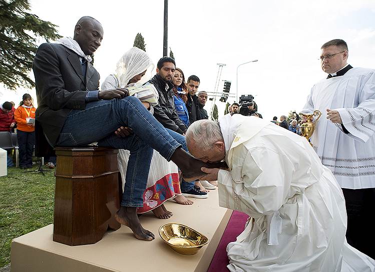 Рим, Италия. Папа римский Франциск омывает и целует ноги беженцам