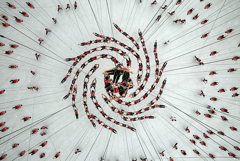 Ученики шаолиньской школы боевых искусств Тагу висят в воздухе в ходе подготовки номера, который был показан на церемонии открытия юношеских Олимпийских игр 2014 года в Нанкине (Китай)