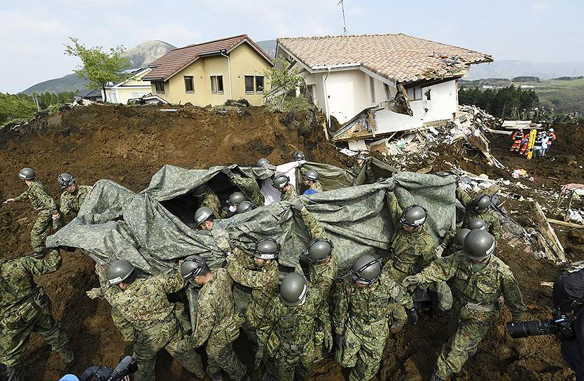 Минамиасо, Япония. Солдаты сухопутных сил самообороны несут человека, спасенного из-под завалов после землетрясения