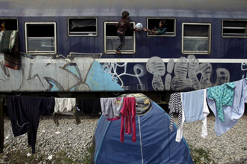 Идомени, Греция. Дети, играющие в вагоне поезда во временном лагере мигрантов, застрявших у границы с Македонией