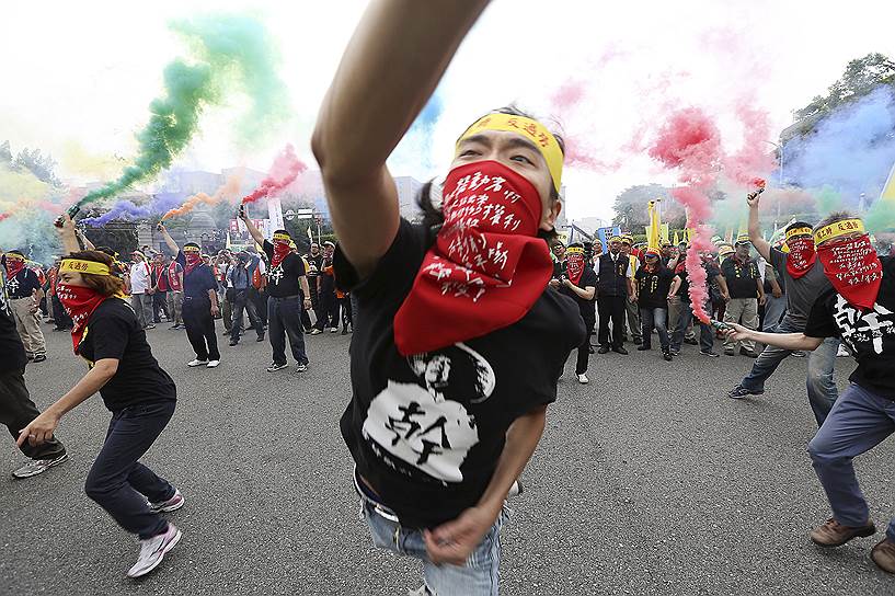 Люди бросают дымовые шашки во время ежегодной акции протеста  в День труда в Тайбэе, Тайвань