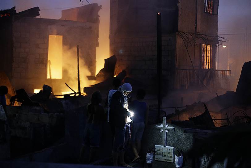Пасай, Филиппины. Местные жители осматривают последствия пожара, уничтожившего несколько домов у кладбища