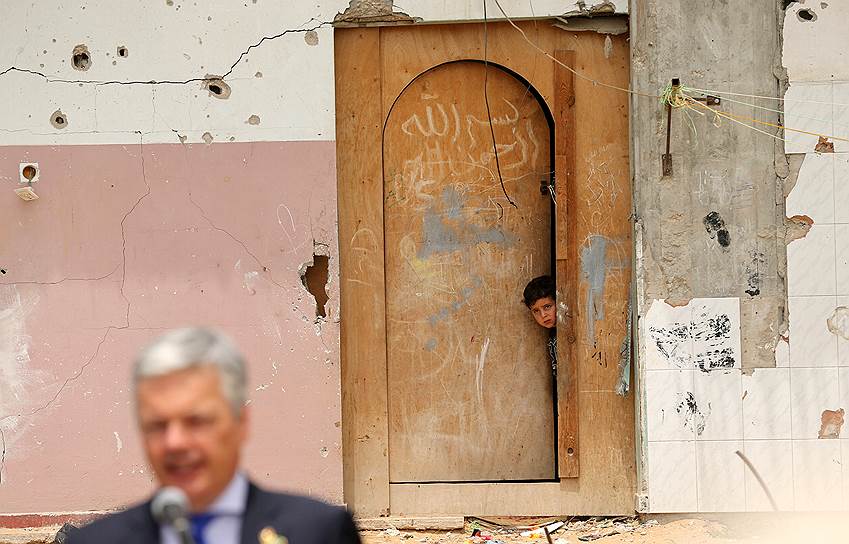 Газа, Палестина. Палестинский мальчик смотрит из разрушенного во время войны дома на министра иностранных дел Бельгии Дидье Рейндерса
