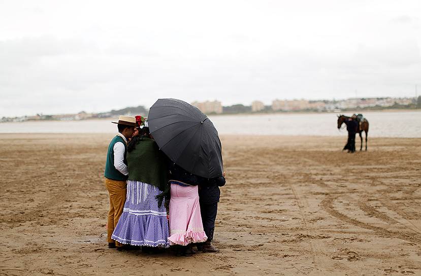 Эль Росио, Испания. Паломники укрываются от дождя на пути в храм 