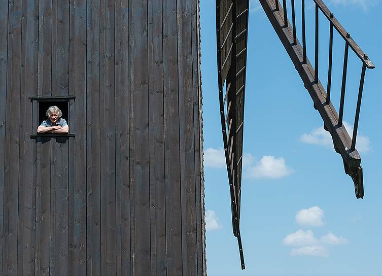 Вильгельмзаю, Германия. Женщина выглядывает из окна своей ветряной мельницы