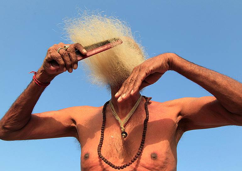 Удджайн, Индия. Мужчина расчесывает бороду после ритуального омовения в реке Шипра в честь праздника Кумбха-мела