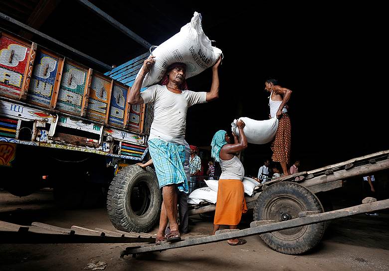 Калькутта, Индия. Грузчики носят мешки с сахаром на оптовом рынке