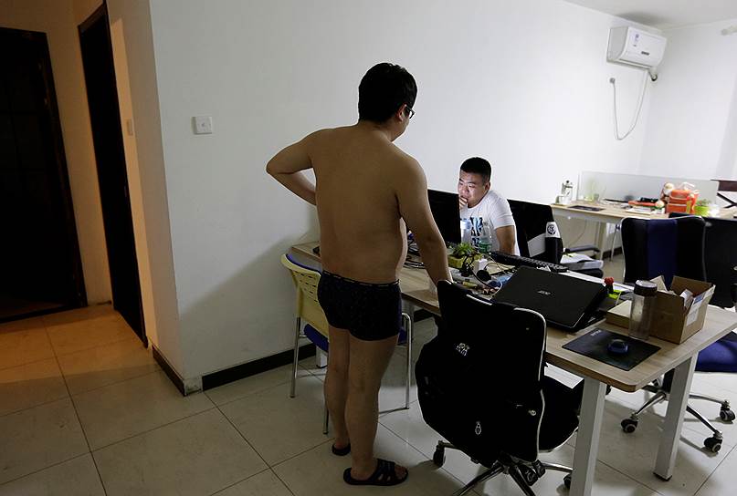 Чжан Хуэйчао (слева), программист пекинского отделения компании N-Wei Technology Company Limited, общается перед сном с коллегой Янь Сяолуном. Компания снимает для них квартиру, в которой они одновременно живут и работают