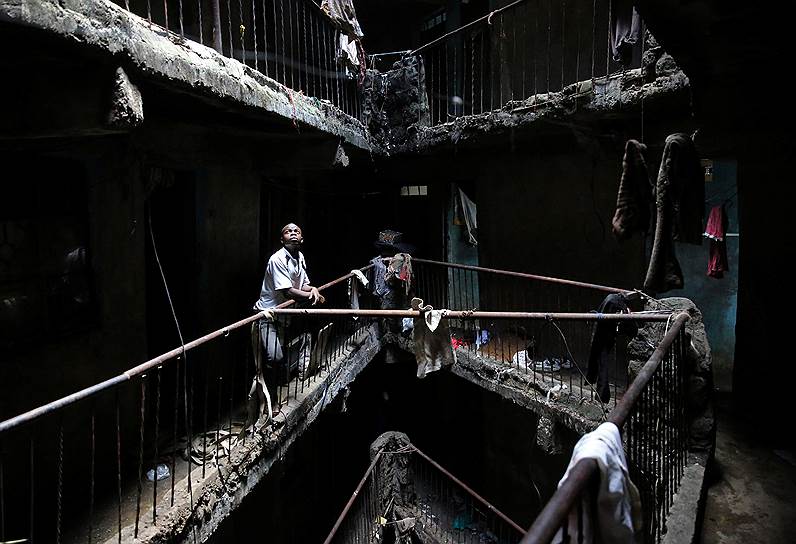 Найроби, Кения. Человек стоит на лестнице здания, подготовленного к сносу 