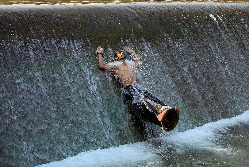 Исламабад, Пакистан. Мужчина плавает в реке, спасаясь от зноя