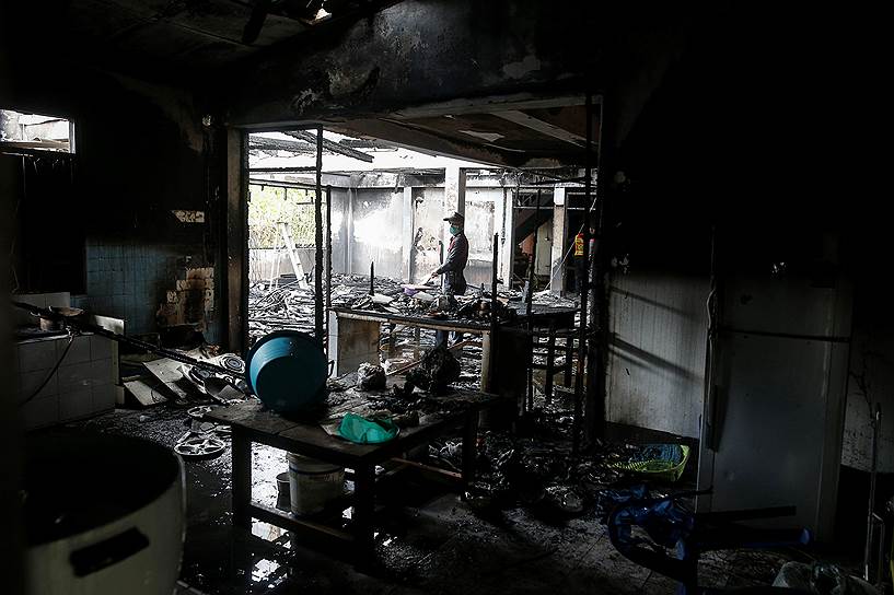 Чианграи&amp;#774;, Таиланд. Судебно-медицинский эксперт осматривает сгоревшее здание школы 