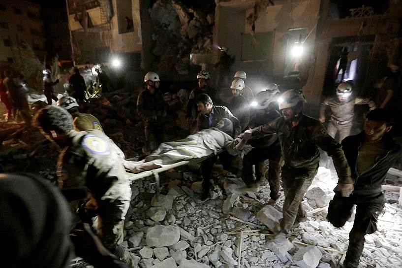 Идлиб, Сирия. Спасатели несут на носилках пострадавшую в результате авиаудара женщину 