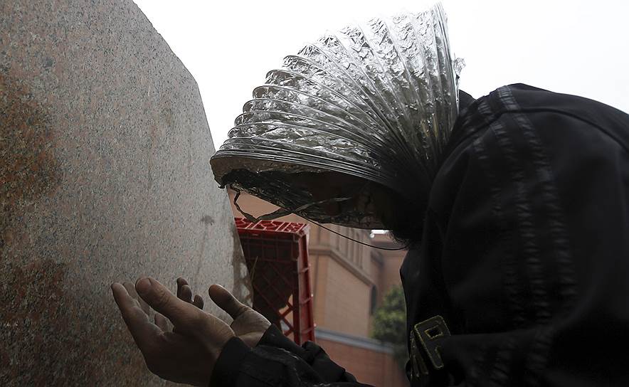 Февраль 2011-го. Беспорядки в Египте. Протестующий с куском вентиляционной трубы на голове во время молитвы