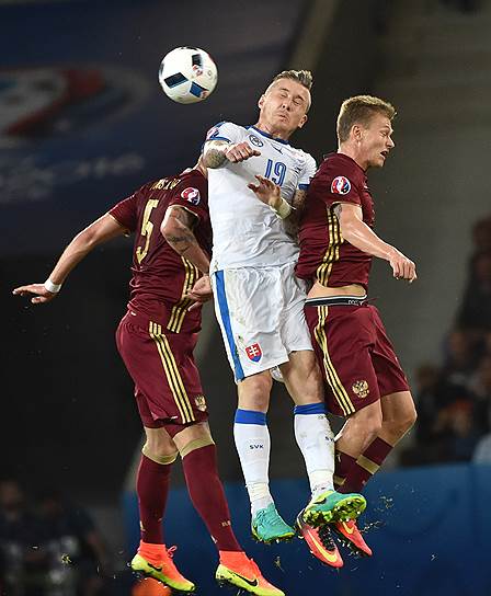 Полузащитник сборной Словакии Юрай Куцка в борьбе за верховой мяч с российскими защитниками