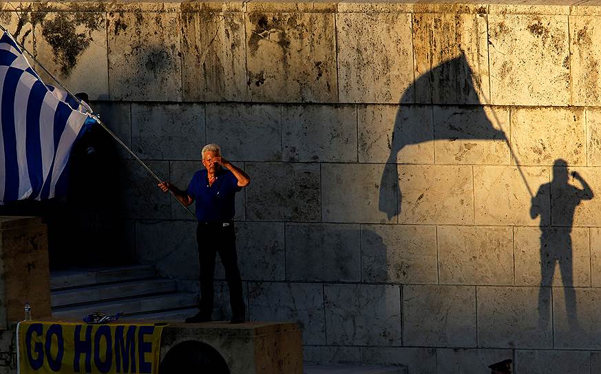 Афины, Герция. Один из митингующих размахивает флагом в ходе антиправительственных акций протеста
