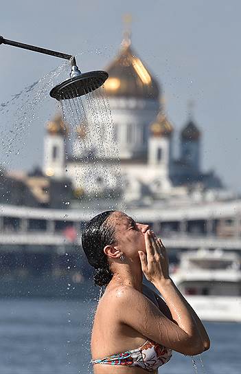 Москва, Россия. Девушка принимает душ на набережной Москва-реки