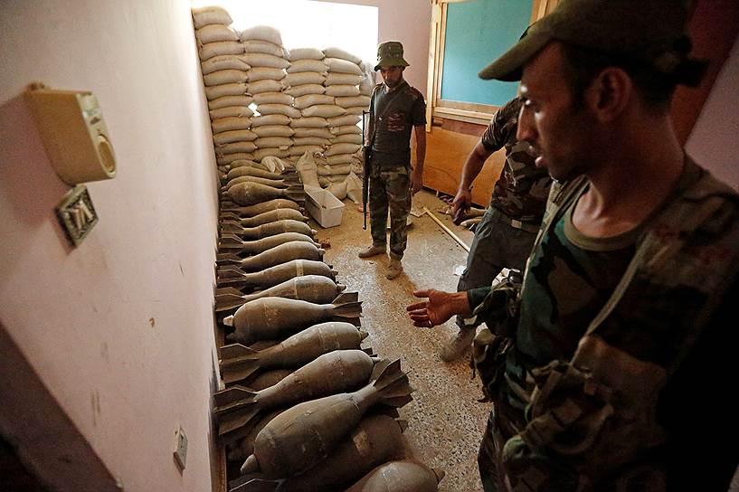 Военнослужащие осматривают боеприпасы, оставленные террористами