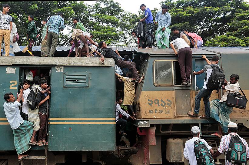 Дакка, Бангладеш. Пассажиры пытаются забраться на крышу переполненного поезда 