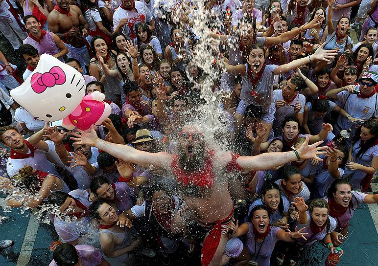 Памплона, Испания. Посетителей фестиваля Сан-Фермин поливают водой с балкона 