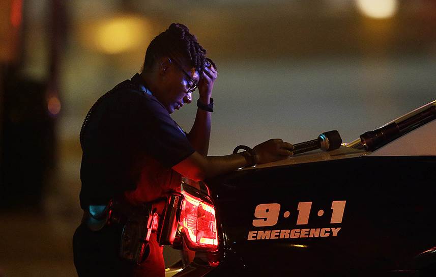 Даллас, США. Женщина-полицейский на месте стрельбы, в результате которой погибли пятеро полицейских. Причиной смерти офицеров стали действия снайперов, открывших огонь в Далласе с «возвышений» во время митинга против убийства чернокожих полицией
