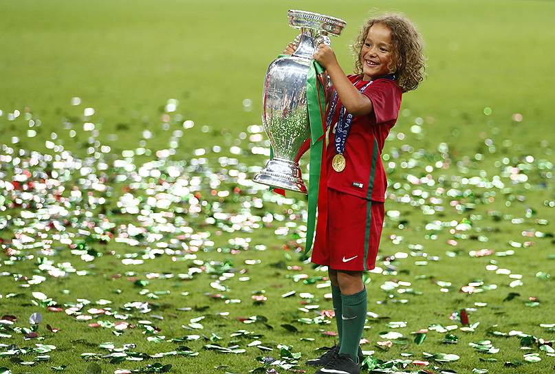 Ребенок футболиста сборной Португалии с кубком отмечает победу на Евро-2016