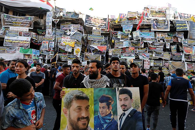 Багдад, Ирак. Горожане держат портреты погибших в результате теракта, совершенного смертником в Багдаде 