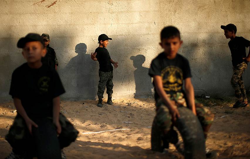 Хан-Юнис, сектор Газа. Палестинские мальчики наблюдают за торжественной военной выпускной церемонией в летнем лагере, организованном исламским джихадистским движением