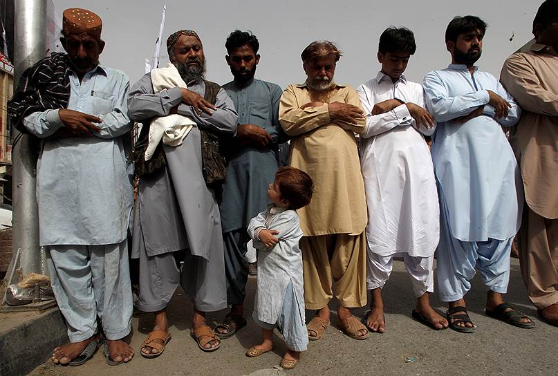 Кветта, Пакистан. Ребенок смотрит, как сторонники запрещенной исламской благотворительной организации «Джамаат-уд-Дава» молятся во время акции протеста против индийских властей