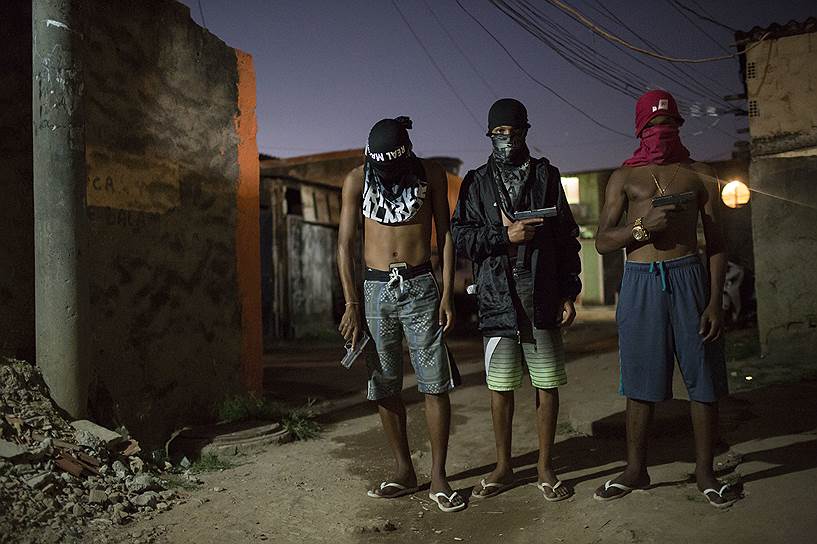 Молодые наркоторговцы с оружием в руках позируют для фотографии 
