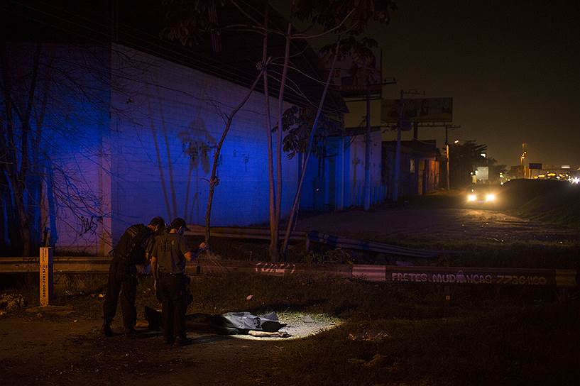 Полицейские осматривают тело убитого 