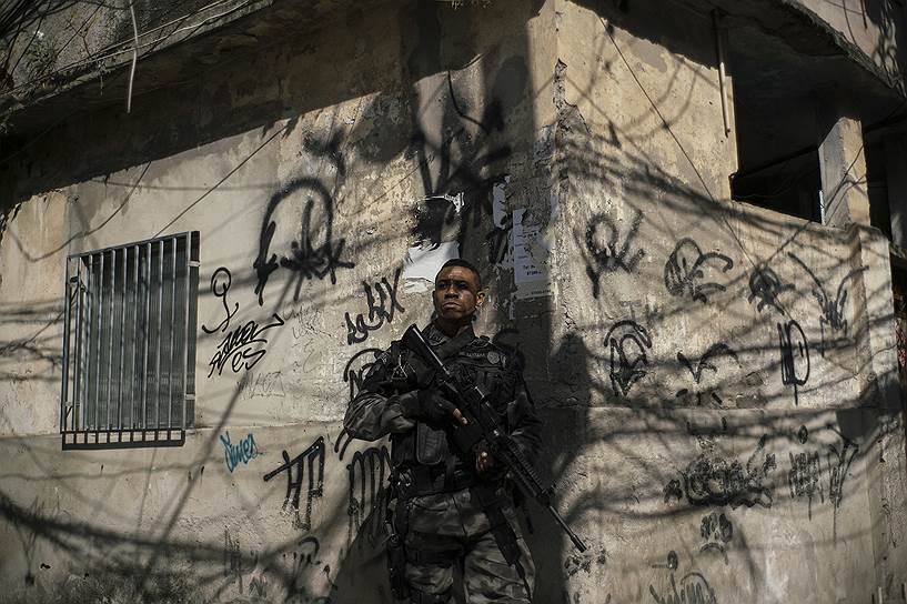 Сотрудник полиции во время операции против наркоторговцев в трущобах Рио-де-Жанейро