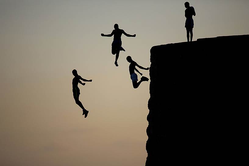Акко, Израиль. Арабские мальчики прыгают в Средиземное море с древних стен, окружающих Старый город