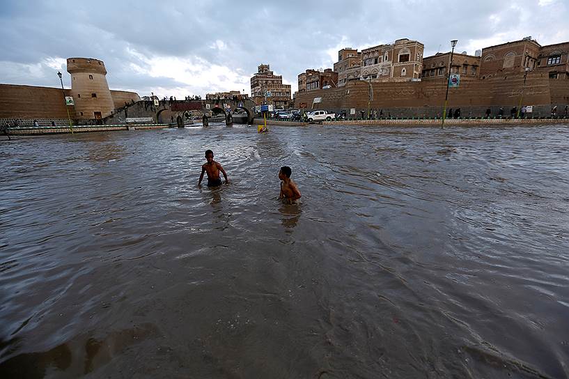 Сана, Йемен. Дети играют в воде на улицах города после наводнения